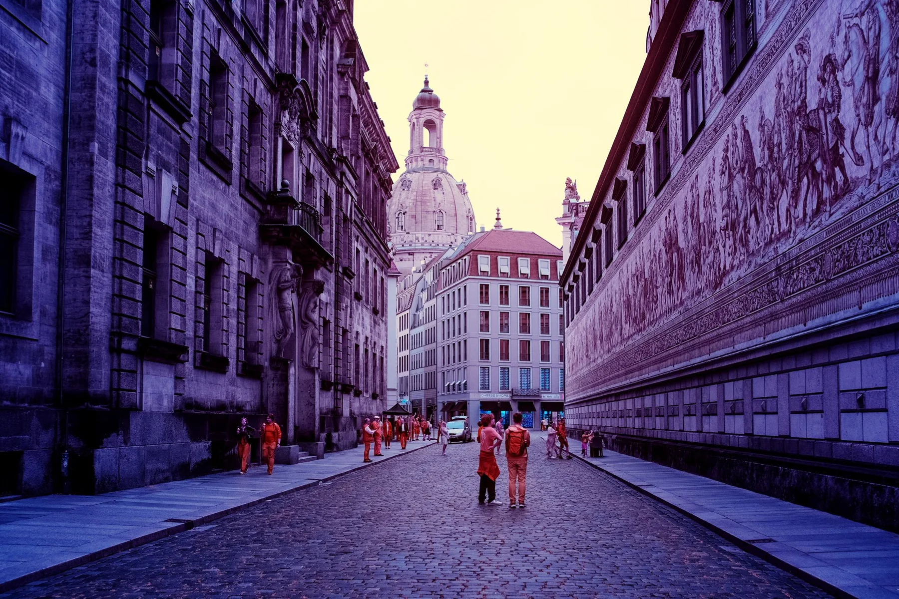 Historic street with a dome in the background.