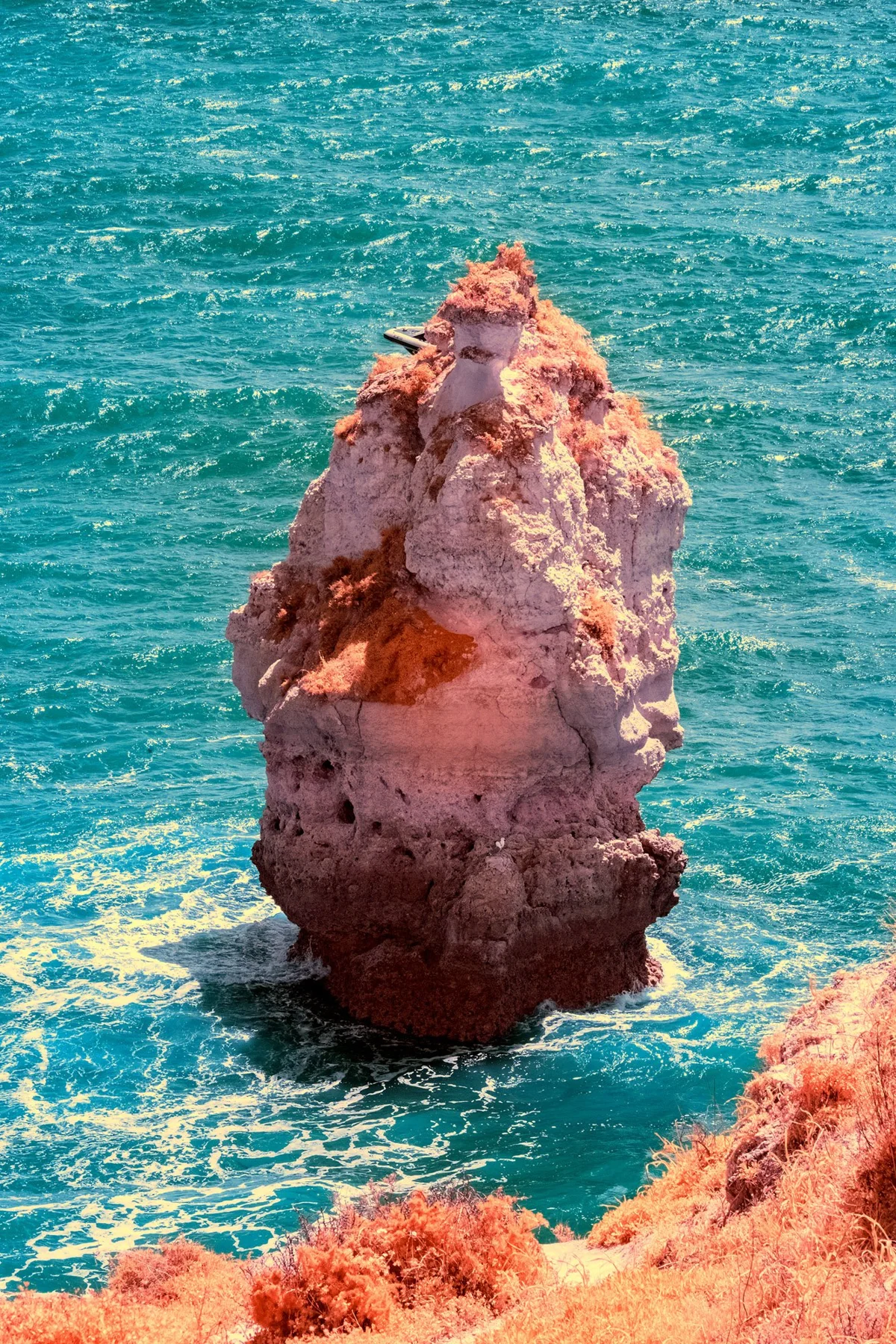 A single rock in the sea surf.