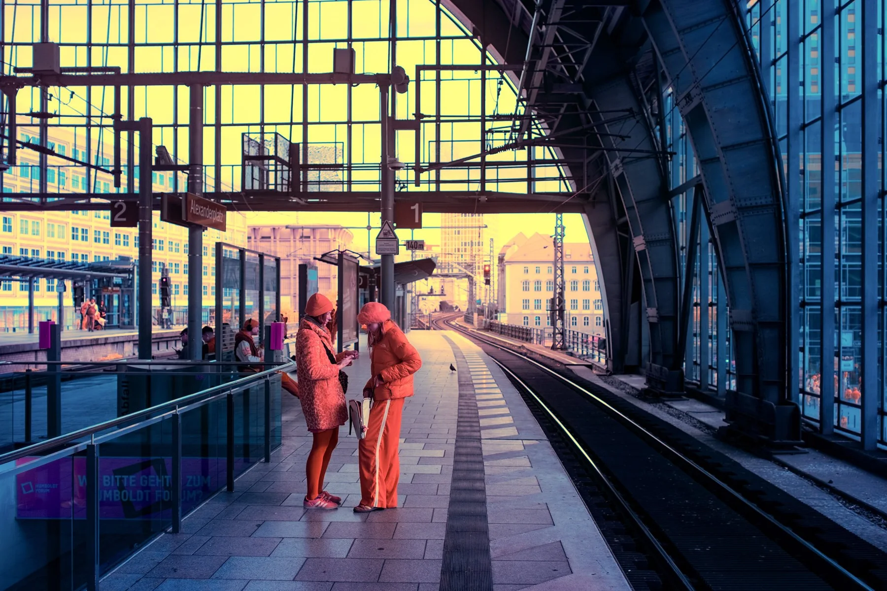 Zwei Menschen auf einem Bahnsteig.