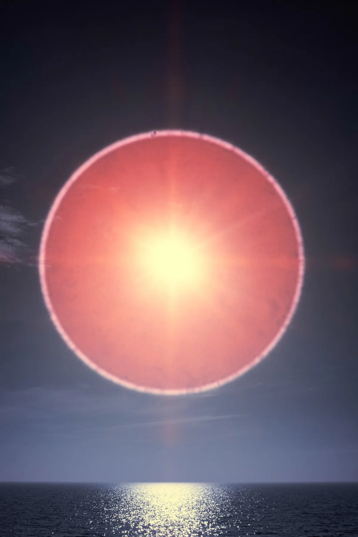 Great red circle of light over the sea.