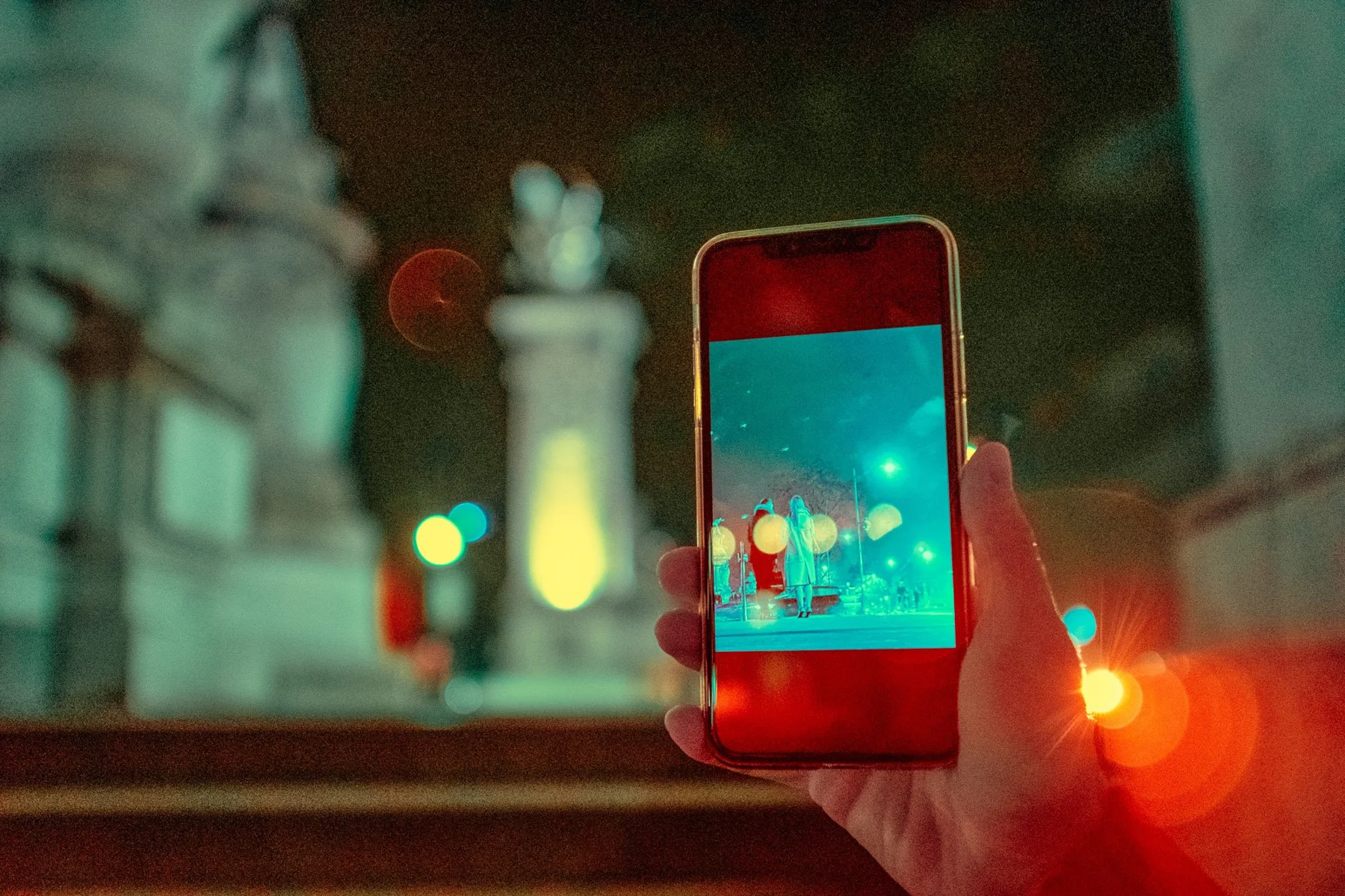 A smartphone in front of the lights of a night city.